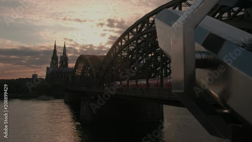 Camera slides past binoculars to reveal Hohenzollernbrucke and Cologne Cathedral at susnet photo