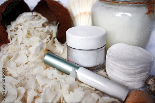Sliced coconut pulp as an ingredient for coconut oil. A concept for facial and body care at home or procedures in the beauty spa. Cosmetic jars without logo: mocap, copy space.