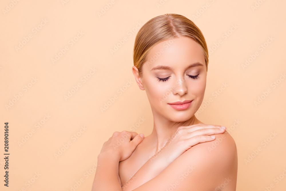 Portrait with copy space empty place for advertisement product of dreamy cute girl with perfect ideal skin, close eyes, touching her shoulders enjoying effect isolated on beige background Portrait with copy space empty place for advertisement product of dreamy cute girl with perfect ideal skin, close eyes, touching her shoulders enjoying effect isolated on beige background