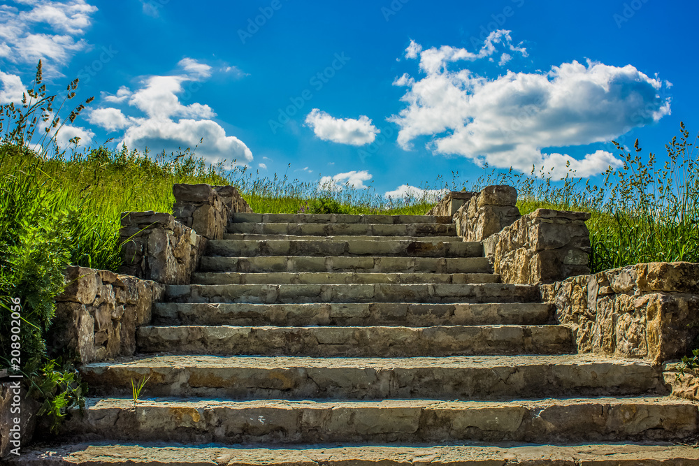 old stones stairs in calm field and blue sky clouds nature landscape concept with empty space for copy or text