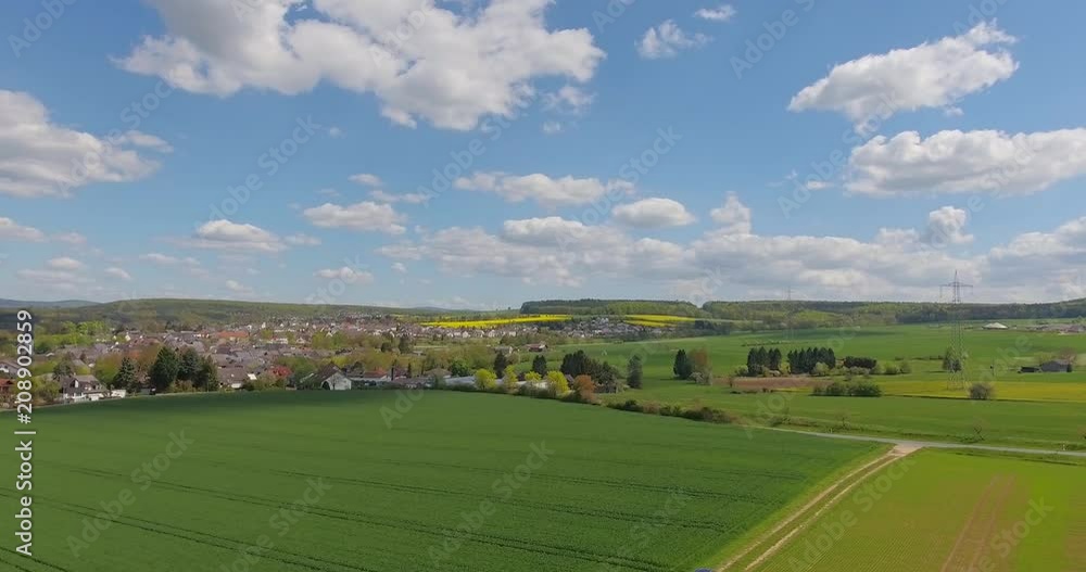 Beautiful small green village from above.Aerial view of a green rural area under blue sky with clouds on a warm summer day. Beautiful small green village from above.Aerial view of a green rural area under blue sky with clouds on a warm summer day.