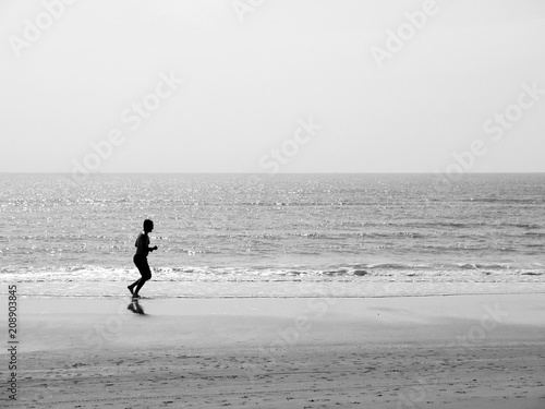 silhouette of a runner man running on the beach