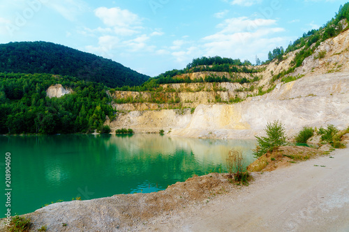 Beautiful landscape, lake in quarry with mountain in background.