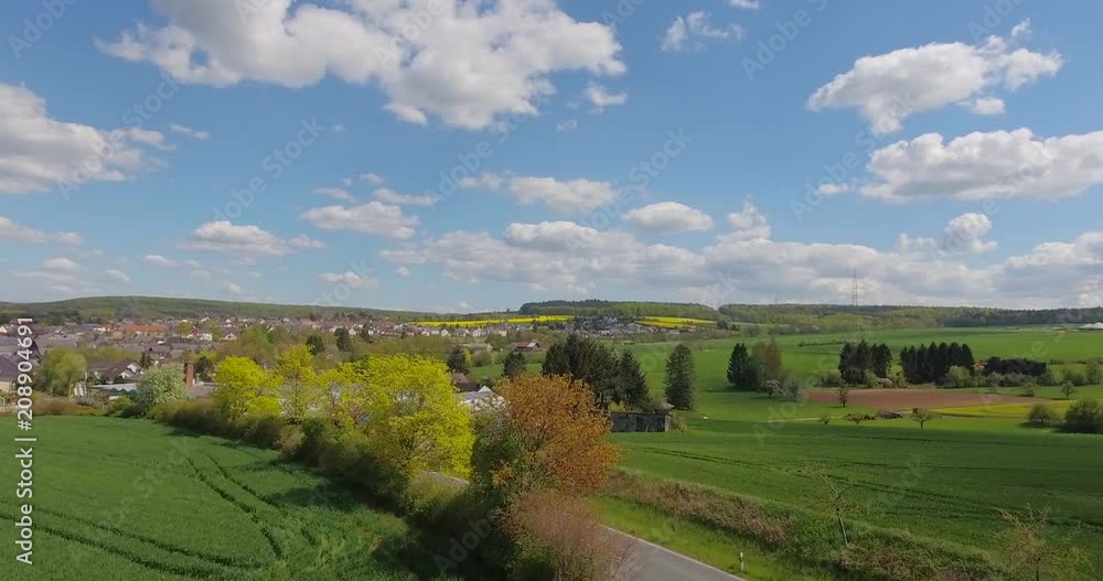 Beautiful small green village from above.Aerial view of a green rural area under blue sky with clouds on a warm summer day. Beautiful small green village from above.Aerial view of a green rural area under blue sky with clouds on a warm summer day.