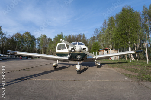 Single-engine small plane is on the runway. Front view.