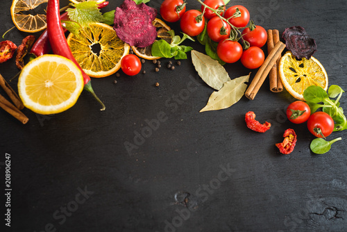 Differen vegetables food ingredients and spices on black background