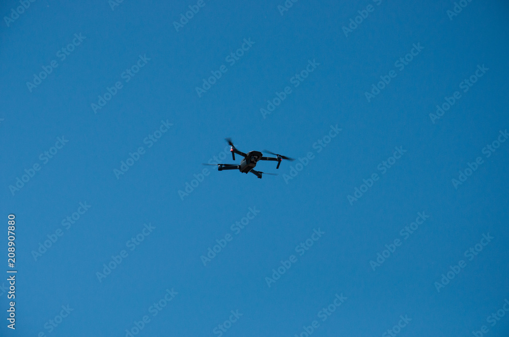 Black quadrupter with propellers flies in the sky and photographs landscapes Black quadrupter with propellers flies in the sky and photographs landscapes