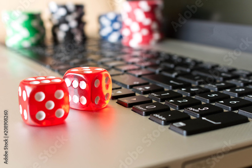 Dice, poker chips on the laptop. The concept of online games. Close up