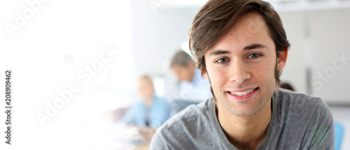 Portrait of smiling student in school class, template