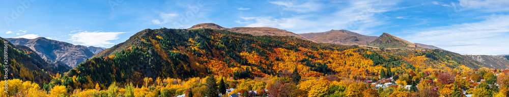 Panorama view of Arrowtown, New Zealand. Beautiful green yellow orange and red autumn trees with the town. Panorama view of Arrowtown, New Zealand. Beautiful green yellow orange and red autumn trees with the town.