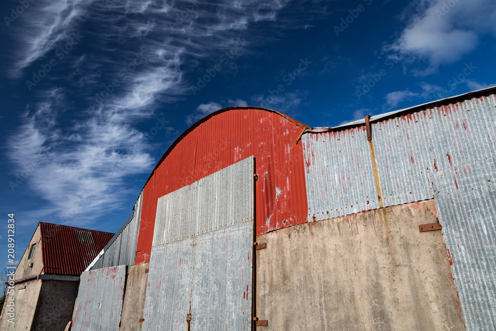 old corrugated iron farmland barn structure, blue sky background old corrugated iron farmland barn structure, blue sky background