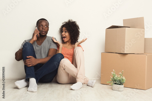 Black couple sitting on floor at new apartment © Prostock-studio