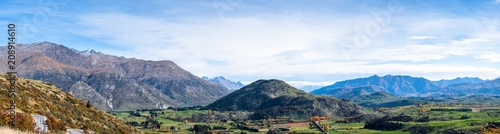 Panorama view of a beautiful road between Queenstown and Wanaka via Crown range. Grassland autumn trees with beautiful landscape of rocky mountains.
