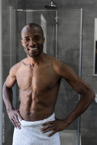 Wallpaper Mural handsome bare-chested african american man in towel standing with hands on waist and smiling at camera in bathroom Torontodigital.ca