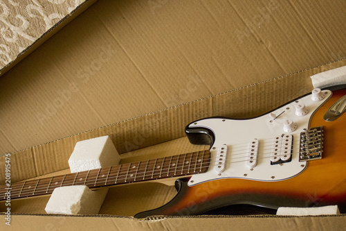 electric guitar is in a cardboard box