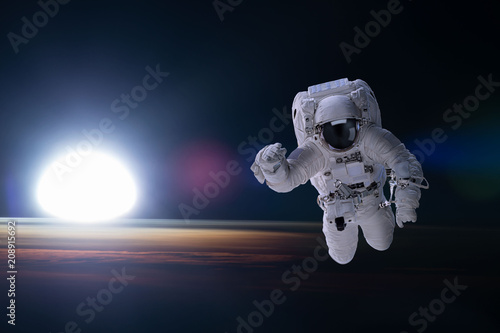 Astronaut in outer space on background of the night Earth. Elements of this image furnished by NASA.