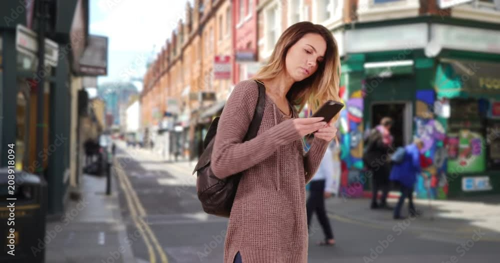 Young woman walks through hipster neighborhood using smartphone for directions, Pretty Caucasian girl wandering down urban street using mobile phone, 4k Young woman walks through hipster neighborhood using smartphone for directions, Pretty Caucasian girl wandering down urban street using mobile phone, 4k