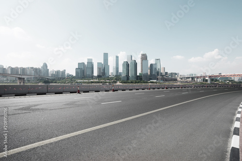 empty asphalt road with modern city skyline © zhu difeng