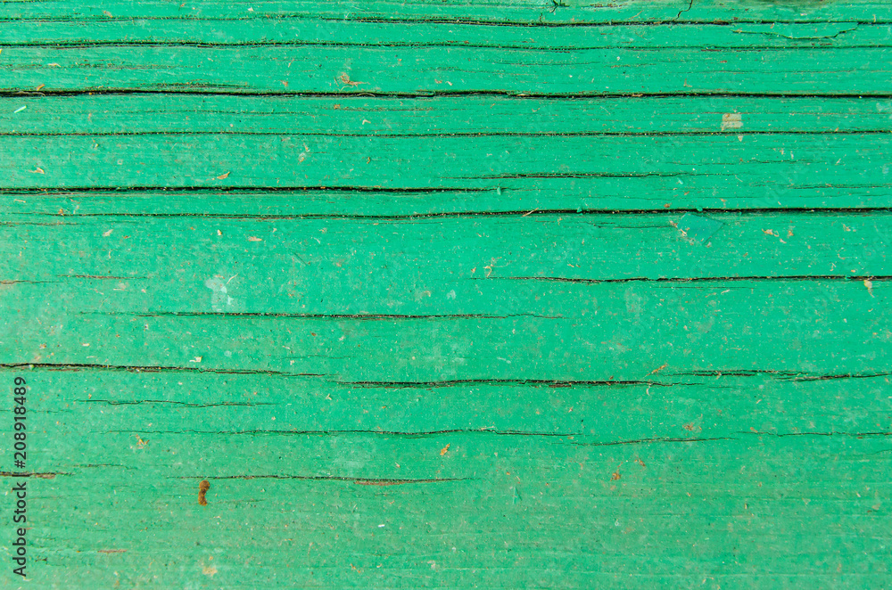 The texture of the cracked green wooden board