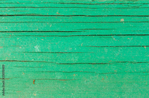 The texture of the cracked green wooden board
