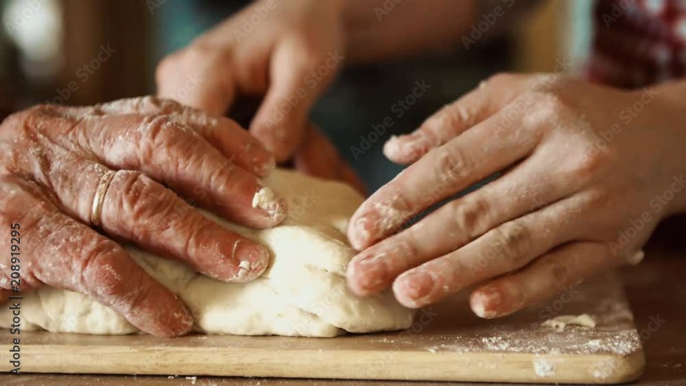 An elderly grandmother with an adult granddaughter at home, baking. An elderly grandmother with an adult granddaughter at home, baking.