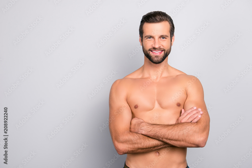 Portrait with copy space of attractive, virile, harsh, sporty, manly, stunning man with crossed arms, muscular, naked torso, looking at camera, isolated on gray background