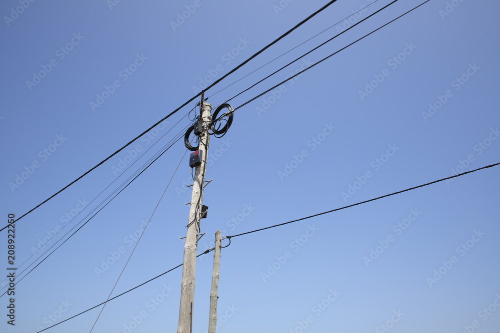 Electricity poles and lines against a blue sky Electricity poles and lines against a blue sky