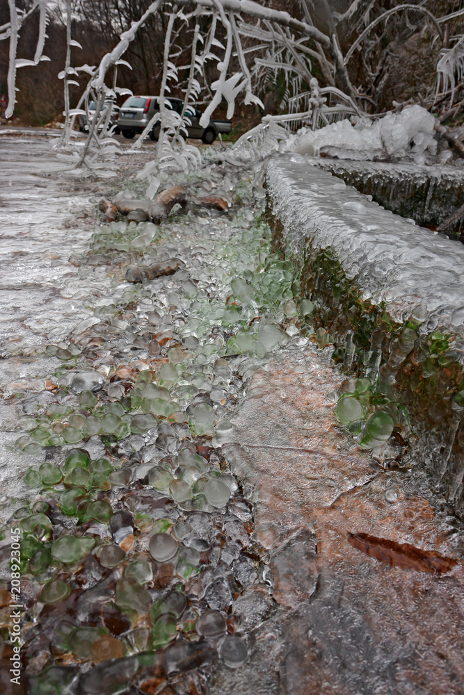 View of rocks and branches covered with ice on a cold winter day. View of rocks and branches covered with ice on a cold winter day.