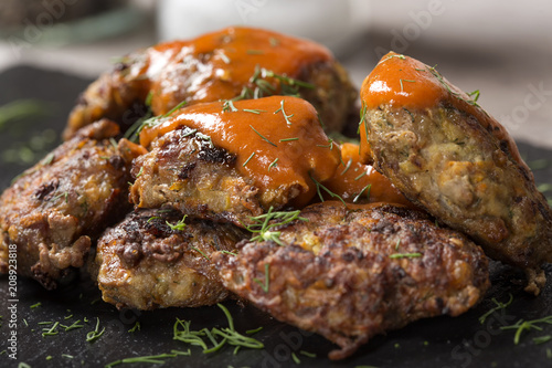 Romanian traditional food "chiftele" or "parjoale" with tomato sauce