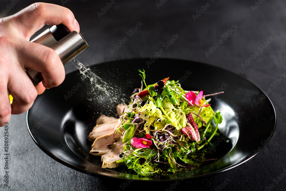 A chef spray oil on the salad Stock Photo | Adobe Stock