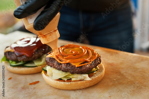 Canvastavla The chef prepares a burger in the open air kitchen