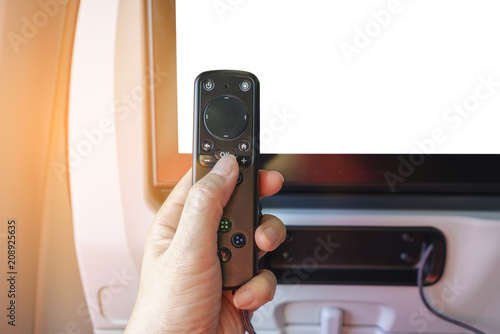 Quadro em tela Finger press OK on airplane entertainment remote control