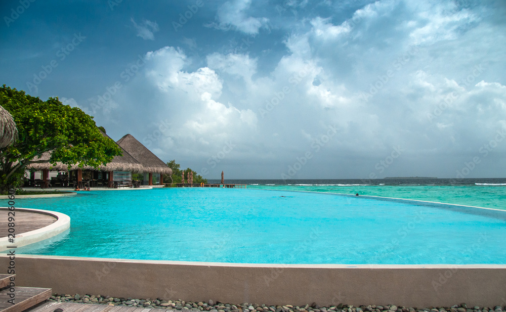 Maldives infinity pool beautiful beach background white sandy tropical paradise island with blue sky sea water ocean 