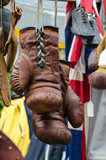An old leather boxing gloves hangs on a market stall.