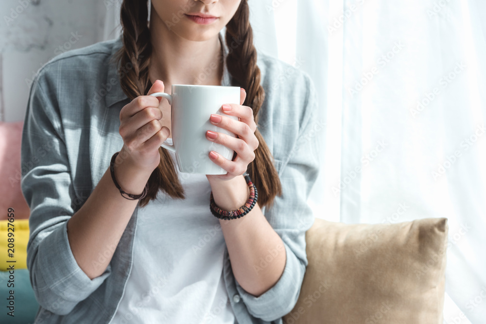 cropped view of teen girl with cup of coffee cropped view of teen girl with cup of coffee