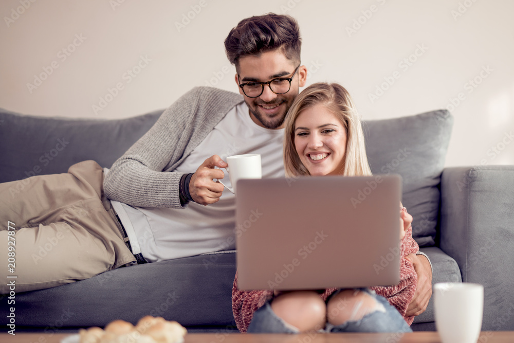 Couple using laptop together at home