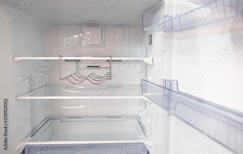 open empty new white refrigerator inside fridge with shelves .
