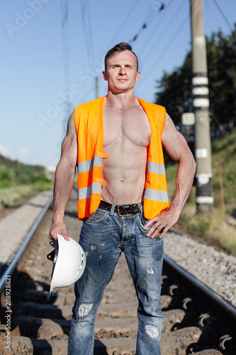 Muscular guy in a construction helmet