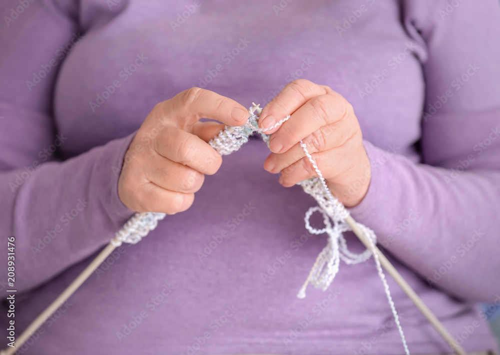 Senior woman knitting sweater, closeup