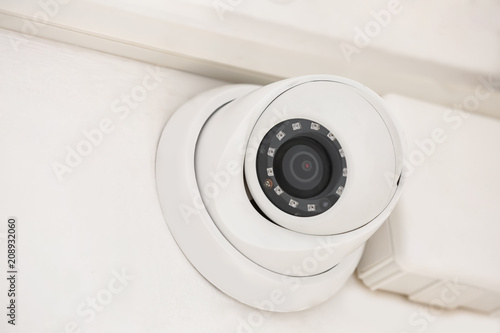 Modern CCTV camera installed on wall in room