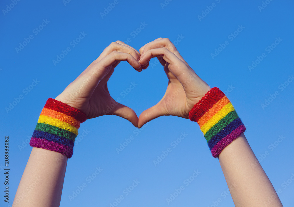 Gay pride concept. Hand making a heart sign with gay pride LGBT rainbow ...