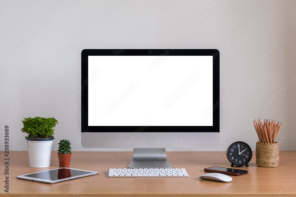 Computer all in one, smart phone, tablet, plnat vase, cactus, pencils and clock on wooden table Computer all in one, smart phone, tablet, plnat vase, cactus, pencils and clock on wooden table