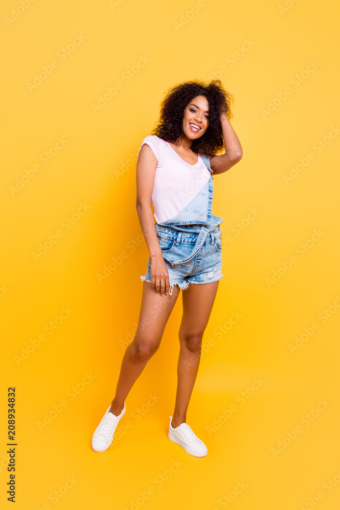 Full size portrait with legs of cheerful funky coquette posing having beaming smile looking at camera isolated on bright yellow background. Vacation weekend holiday concept Full size portrait with legs of cheerful funky coquette posing having beaming smile looking at camera isolated on bright yellow background. Vacation weekend holiday concept