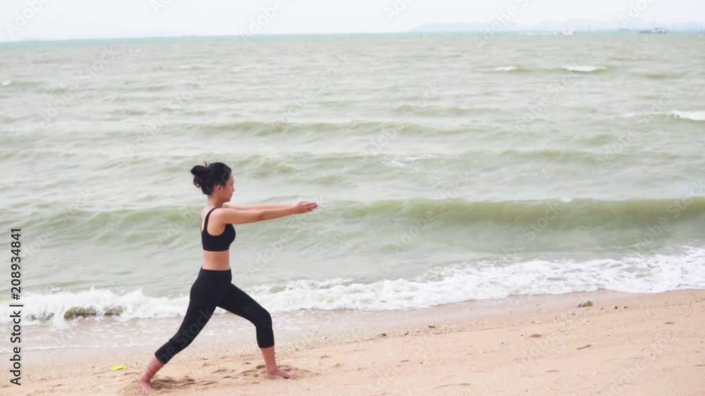 Asia young woman practicing yoga on the beach. Slow motion Asia young woman practicing yoga on the beach. Slow motion