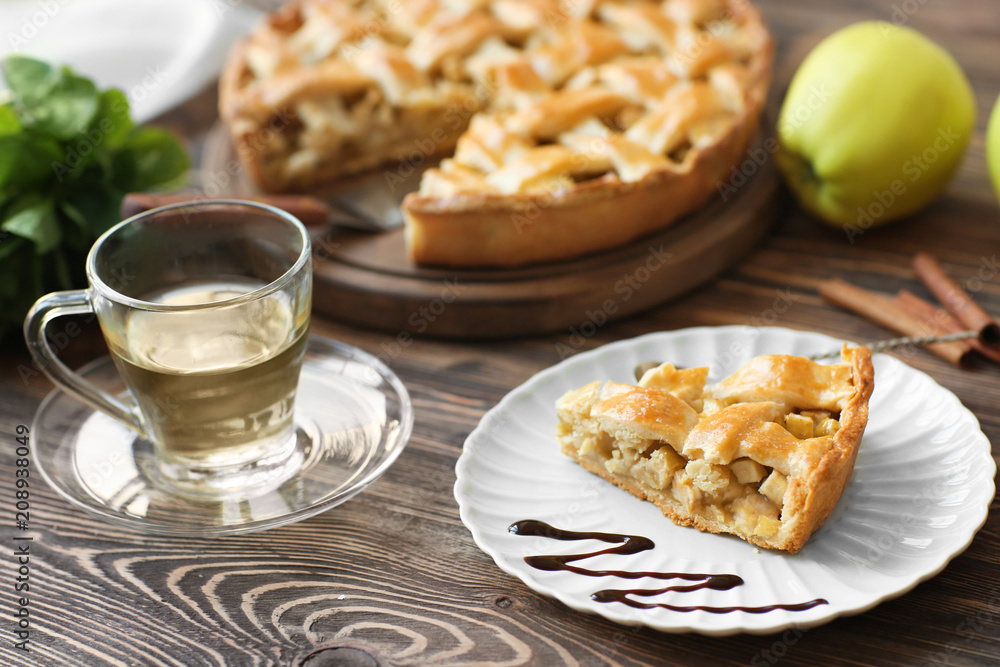 Plate with piece of tasty homemade apple pie on wooden table Plate with piece of tasty homemade apple pie on wooden table