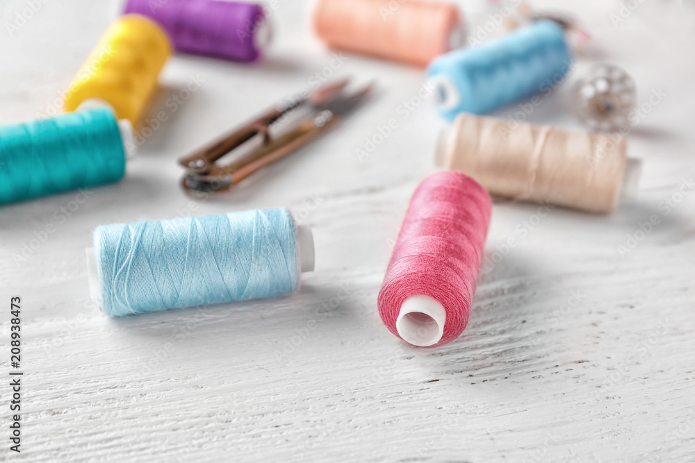 Sewing threads on white wooden background Sewing threads on white wooden background