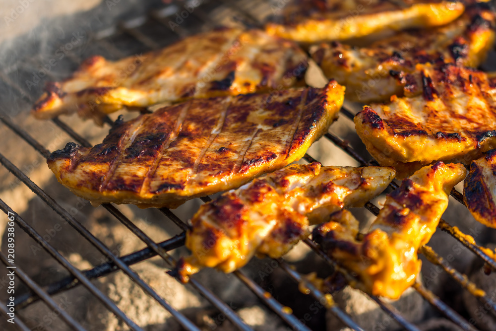Chicken breast steak placed on the hot grill. Bbq meat on fire, summer weather, grill party with friends Chicken breast steak placed on the hot grill. Bbq meat on fire, summer weather, grill party with friends