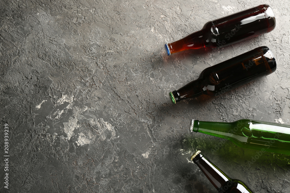 Fresh beer in glass bottles on grey background Fresh beer in glass bottles on grey background