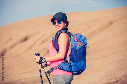 Picture of beautiful tourist woman with backpack and walking sticks
