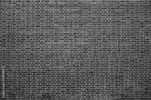 Old realistic brick wall made of black brick in different shads. Burnt smooth brickwork.